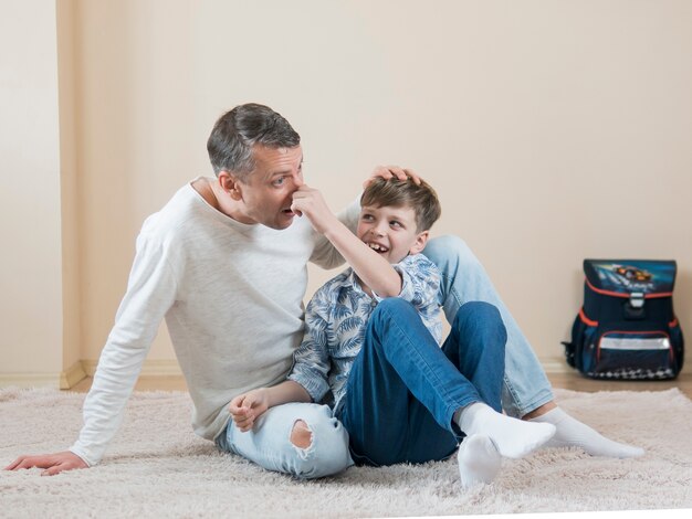 Vater und Sohn sitzen und spielen herum