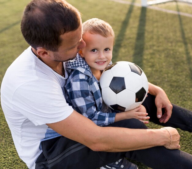 Vater und Sohn spielen auf dem Fußballplatz hohe Ansicht