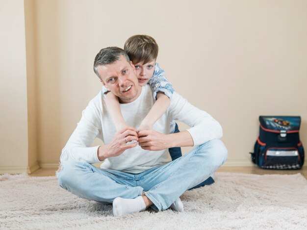 Vater und Sohn spielen auf dem Teppich