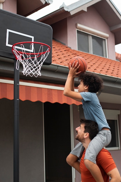 Vater und Sohn spielen gemeinsam Basketball im Hinterhof