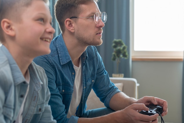 Vater und Sohn spielen lokale Spiele auf der Konsole