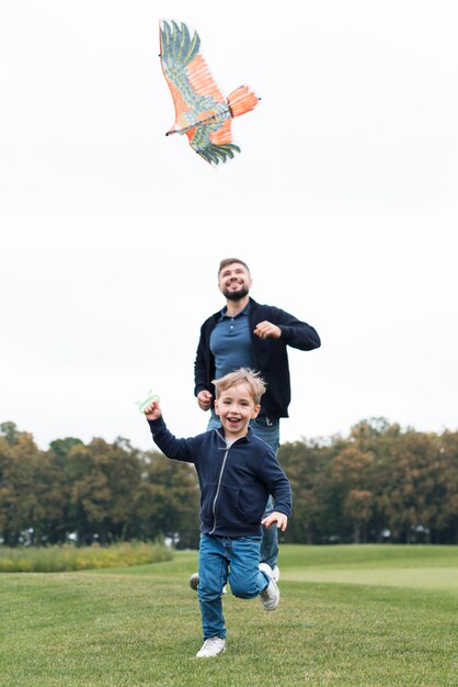 Vater und Sohn spielen mit Drachen Vorderansicht