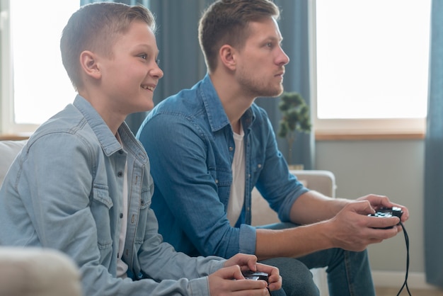 Vater und Sohn spielen zusammen Videospiele