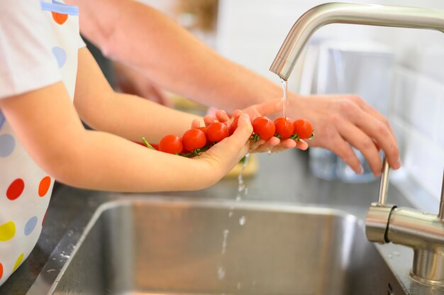 Vater und Sohn waschen die Tomaten