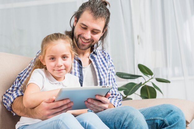 Vater und Tochter, die die Tablette verwenden