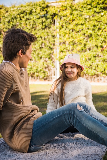 Vater und Tochter, die einander sitzend im Park betrachten