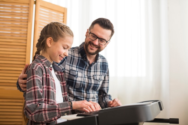 Vater und Tochter spielen am Klavier