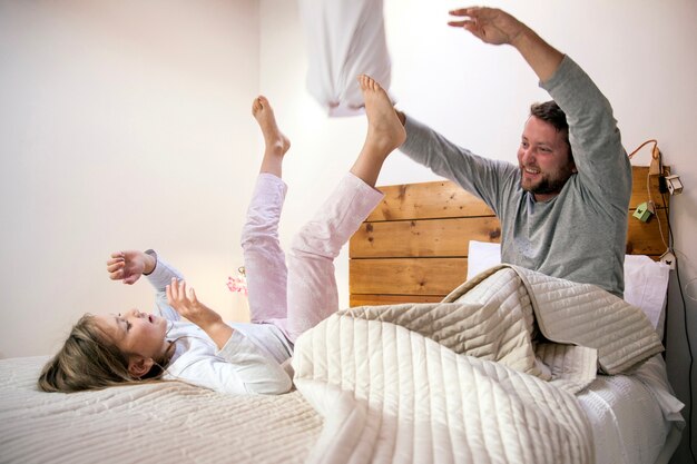 Vater und Tochter spielen im Bett