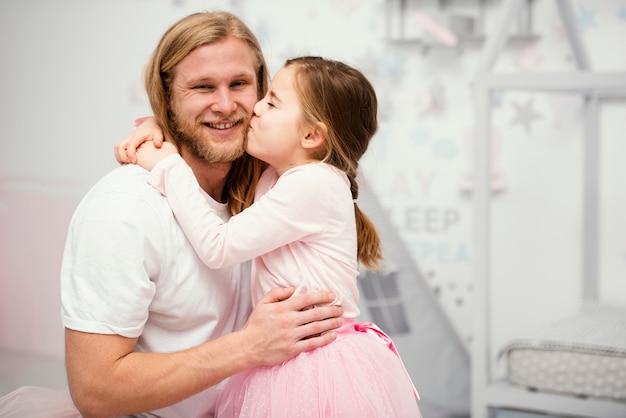 Vater und Tochter umarmen sich zu Hause mit Kopierraum