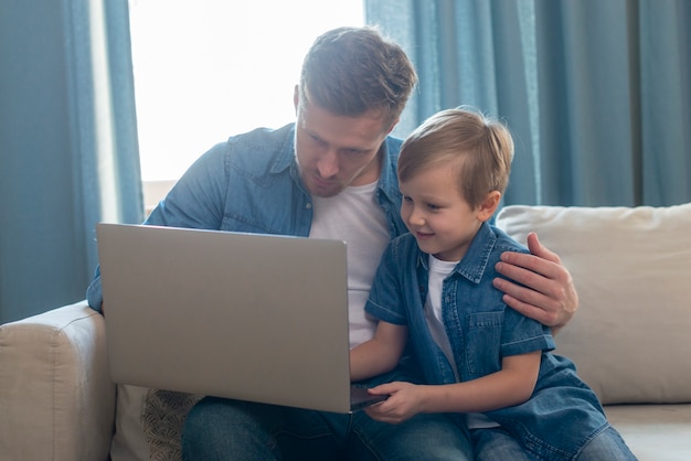 Kostenloses Foto vatertag vater und sohn betrachten laptop