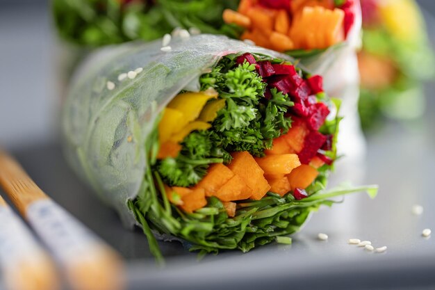 Vegane Reispapierrollen mit Gemüse und Sesam, serviert auf einem Teller, essfertig