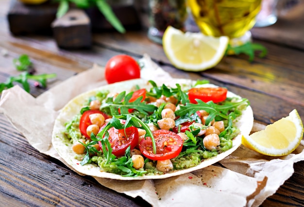 Vegane Tacos mit Guacamole, Kichererbsen, Tomaten und Rucola. Gesundes Essen. Nützliches Frühstück