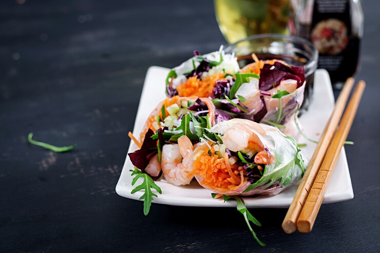 Kostenlose Foto vegetarische vietnamesische frühlingsrollen mit würzigen garnelen, garnelen, karotten, gurken, rotkohl und reisnudeln.