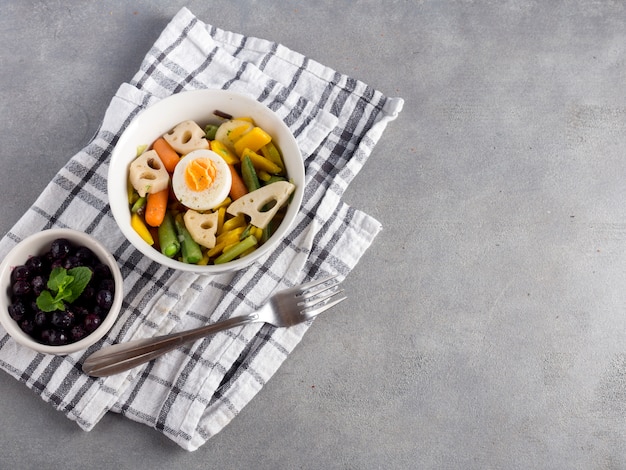 Kostenloses Foto vegetarischer salat mit beeren auf grauer tabelle