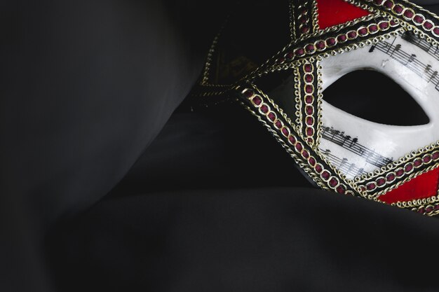 Venezianische Maske für die Augen auf einem schwarzen Stoff