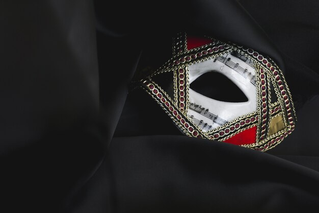 Venezianische Maske für die Augen auf einem schwarzen Stoff
