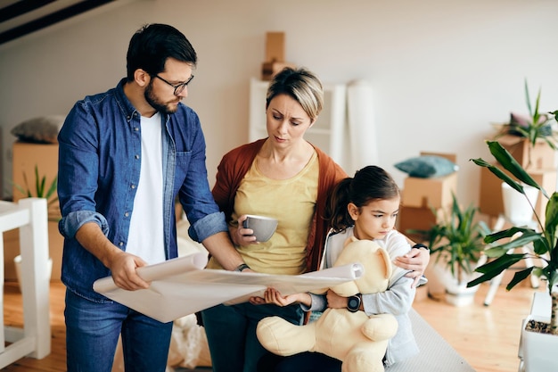 Verärgerte Familie, die Pläne ihrer neuen Wohnung analysiert