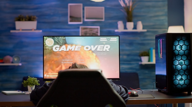 Kostenloses Foto verärgerte professionelle spielerin mit headset, die das weltraum-shooter-spiel im cybersport-wettbewerb verliert. müde profi-cyberspieler, die online-videospiele auf einem leistungsstarken pc mit rgb-licht spielen.