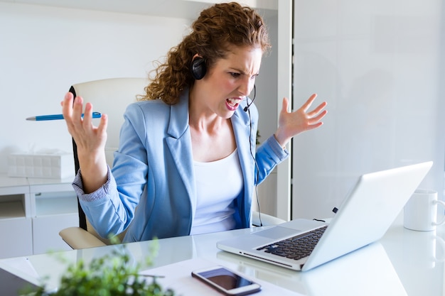 Verärgerter Kundendienstbetreiber, der am Telefon im Büro spricht.