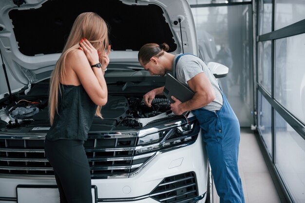 Verbindungen sind schlecht. Ergebnisse der Reparatur. Zuversichtlich Mann zeigt, welche Art von Schaden ihr Auto genommen wurde