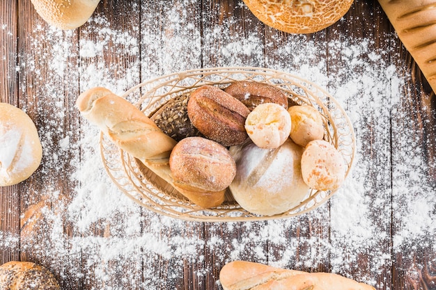 Verbreiten Sie Mehl über dem Brotkorb auf dem Holztisch