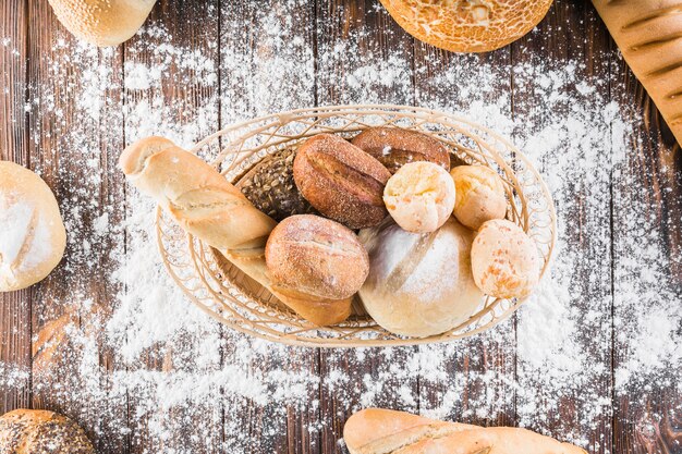 Verbreiten Sie Mehl über dem Brotkorb auf dem Holztisch