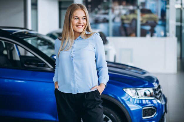 Verkäuferin in einem Autosalon mit dem Auto