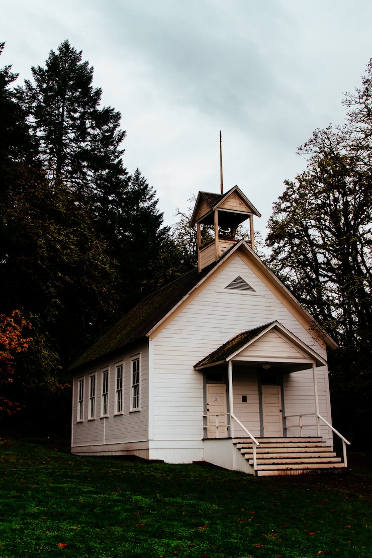 Kostenlose Foto verlassene geschlossene holzkirche in einem wald auf dem land