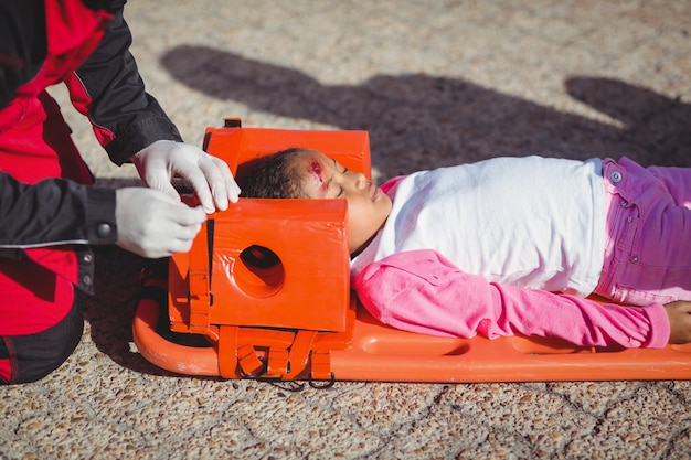 Kostenloses Foto verletztes mädchen von sanitäter behandelt