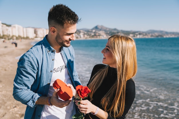 Verliebte Paare mit Geschenken auf Strand