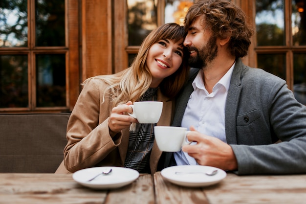 Verliebtes Paar, das in einem Café sitzt, Kaffee trinkt, sich unterhält und die Zeit miteinander genießt. Selektiver Fokus auf Tasse.