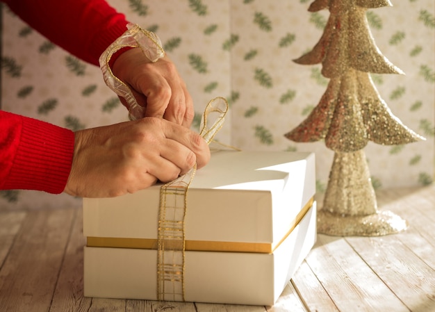 Verpackung eines Weihnachtsgeschenks auf einem Holztisch