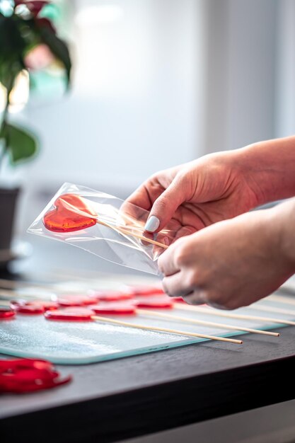 Verpackung von roten Lutschern in Form von Herzen