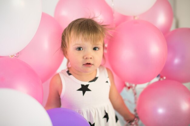 Verrücktes Kleinkind mit Luftballons Kinderurlaub