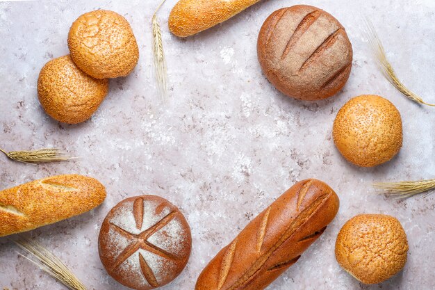 Verschiedene Arten von frischem Brot als Hintergrund, Draufsicht