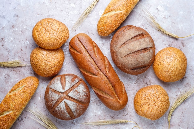 Verschiedene Arten von frischem Brot als Hintergrund, Draufsicht