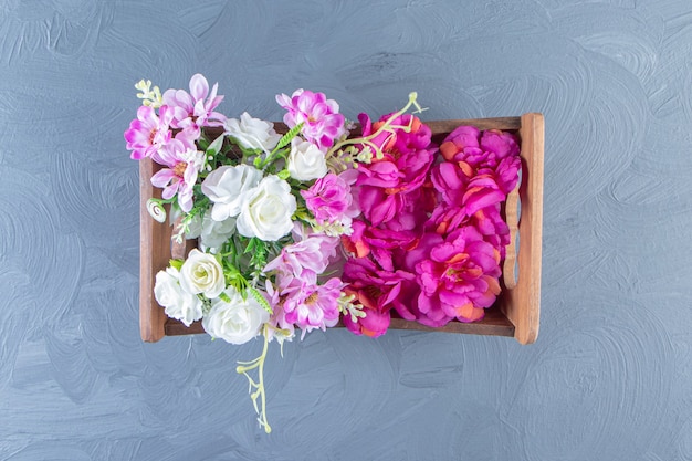 Verschiedene Blumen in einer Schachtel auf dem weißen Tisch.