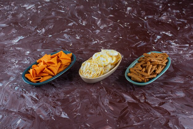 Verschiedene Chips in Schalen, auf dem Marmortisch.