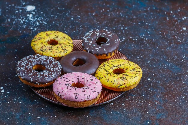 Verschiedene Donuts mit Schokoladenglasur, rosa glasiert und Streuseln.