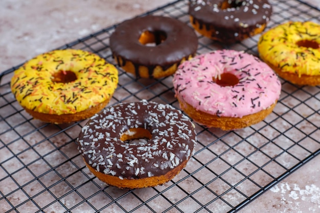 Verschiedene Donuts mit Schokoladenglasur, rosa glasiert und Streuseln.