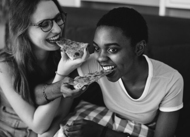 Verschiedene Frauen, die zusammen Pizza essen