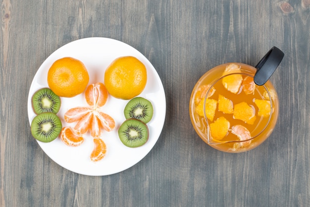 Verschiedene Früchte mit einem Glas Saft in Scheiben schneiden