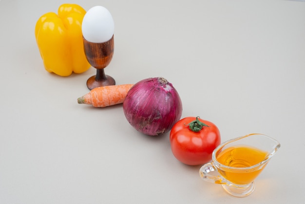 Verschiedene Gemüsesorten mit Ei und Öl auf Weiß.