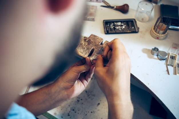 Kostenloses Foto verschiedene goldschmiedewerkzeuge am schmuckarbeitsplatz. juwelier bei der arbeit in schmuck.