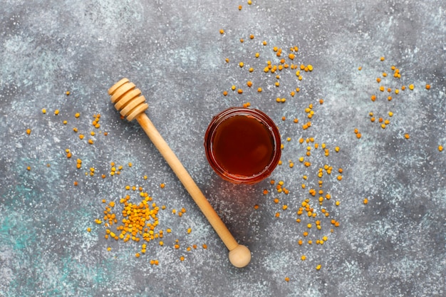 Kostenloses Foto verschiedene honigsorten in gläsern, waben und pollen.