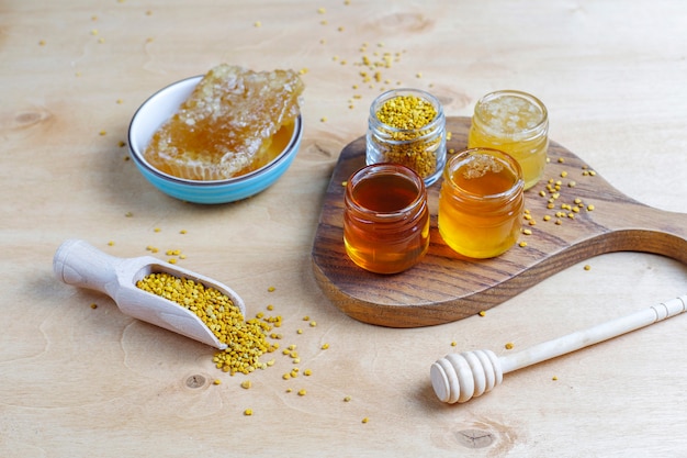Kostenloses Foto verschiedene honigsorten in gläsern, waben und pollen