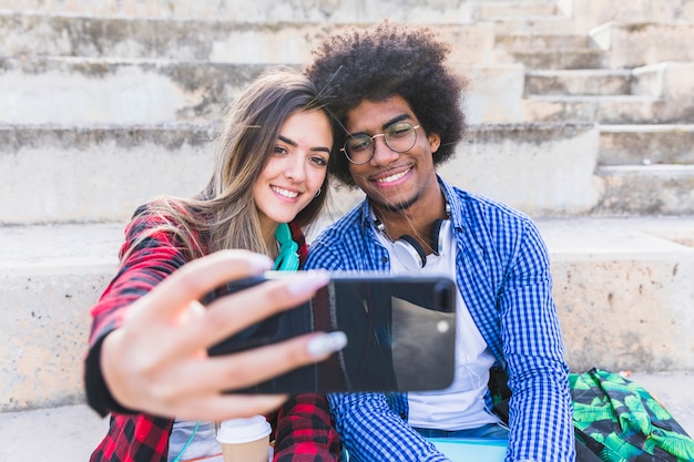 Verschiedene junge Paare, die selfie auf Smartphone nehmen