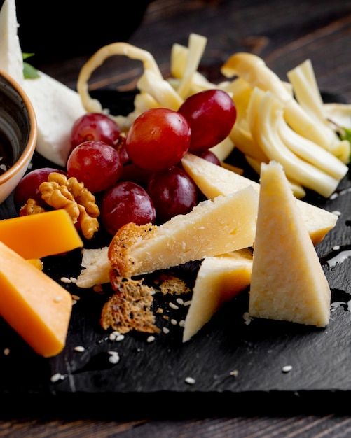 Kostenloses Foto verschiedene käsesorten mit trauben und walnüssen