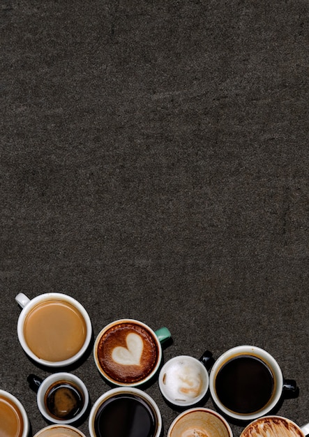 Verschiedene Kaffeetassen auf einem schwarzen Grunge strukturiert