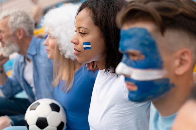 Verschiedene Leute, die eine Fußballmannschaft betrachten